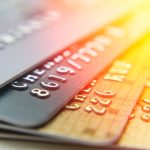 A group of gold and black credit cards and their perks