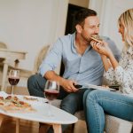 Young couple eating pizza at home