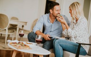 Young couple eating pizza at home