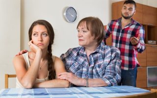 A family arguing with a mother and daughter facing away from a husband