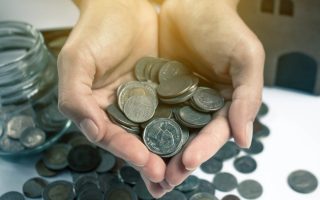 A pair of hands holding a lot of coins