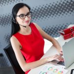 Young attractive businesslady in red dress and glasses