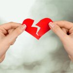 A woman who has been left ripping a paper heart in half