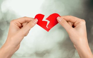 A woman who has been left ripping a paper heart in half