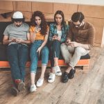 Four Millennial friends hanging out together on a couch