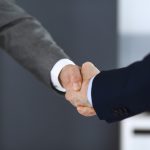 Two people shaking hands, a modern etiquette rule that might actually be offensive