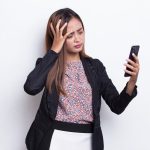 A woman dreading a phone call from her parents