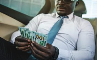 A rich person with his cash, showing a millionaire mindset