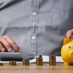 A man being the smart spender for his family with change and a piggy bank