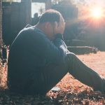 A man in a graveyard experiencing grief