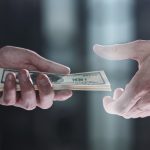 Someone handing cash to another, symbolizing inheritance