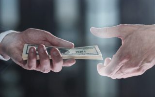 Someone handing cash to another, symbolizing inheritance