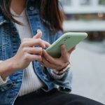 A woman checking her phone, which is a personal habit that people find untrusworthy