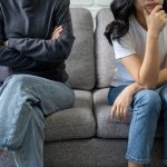 Two siblings sitting apart because they resent each other