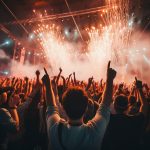A large crowd listening to music at a summer festival