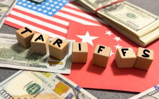 Americn and Chinese flags, with the word tariffs writen on top in blocks