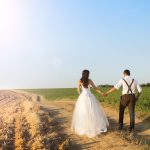 A couple starting their marriage by walking down a dirt road