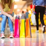 A woman with a lot of bags after overspending at the mall