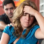 An unhappy woman pushed away by her spouse because of recurring small habits