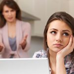 A young woman uncomfortable with how her parents are treating her