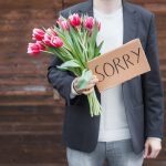A man with flowers offering one of the apologies that do more harm than good