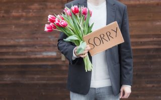 A man with flowers offering one of the apologies that do more harm than good
