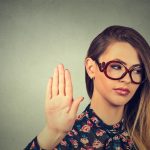 A woman in glasses hearing compliments that are actually deeply insulting