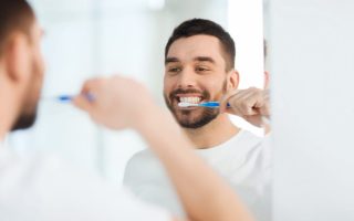 A man brushing his teeth, which is a personal hygiene practice that is good for you