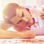 A man with a piggy bank hiding his debt from his partner