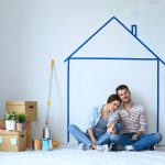 A married couple, painting and relaxing inside their new housing space