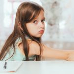 A young girl looking like she is feeling guilt