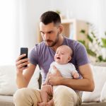 A new father using a parenting app with his child