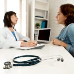 A woman being asked questions by her doctor at a medical checkup