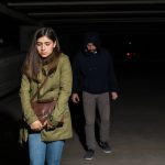 A woman being followed by a stalker in public.