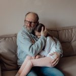A grandparent providing comfort to his granddaughter
