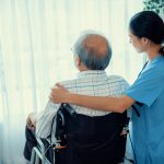 An elderly patient at a nursing home receiving care from a nurse