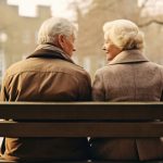 A happy couple in retirement sitting on a bench