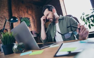 A man looking exhausted and distressed at his workplace