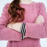A woman crossing her arms, which is a stupid social cue