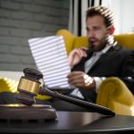 A man in the office of his lawyer, nervously looking at legal paperwork