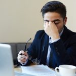 A man looking stressed and passive-aggressive at work